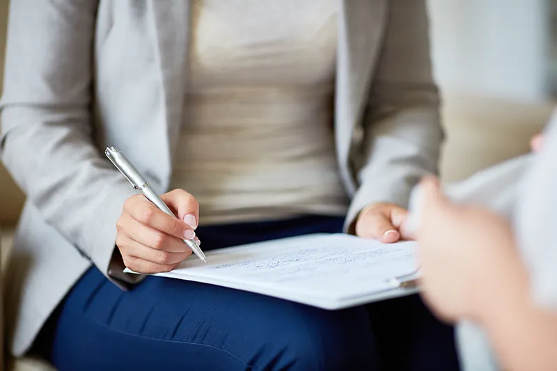 psychology_quiensoy1 Primer plano de una psicóloga tomando notas en una consulta, simbolizando el proceso terapéutico y la atención personalizada en psicología.