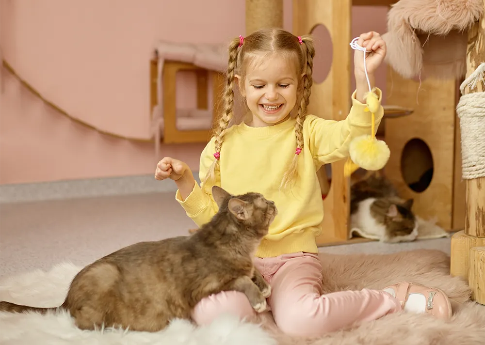terapia_infantil_picon Niña sonriendo mientras juega con un gato en un ambiente acogedor, simbolizando la terapia infantil y el vínculo con los animales.